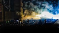 a concert with smoke coming out of the stage